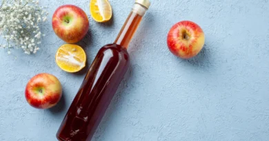 Butelka octu jabłkowego obok świeżych jabłek